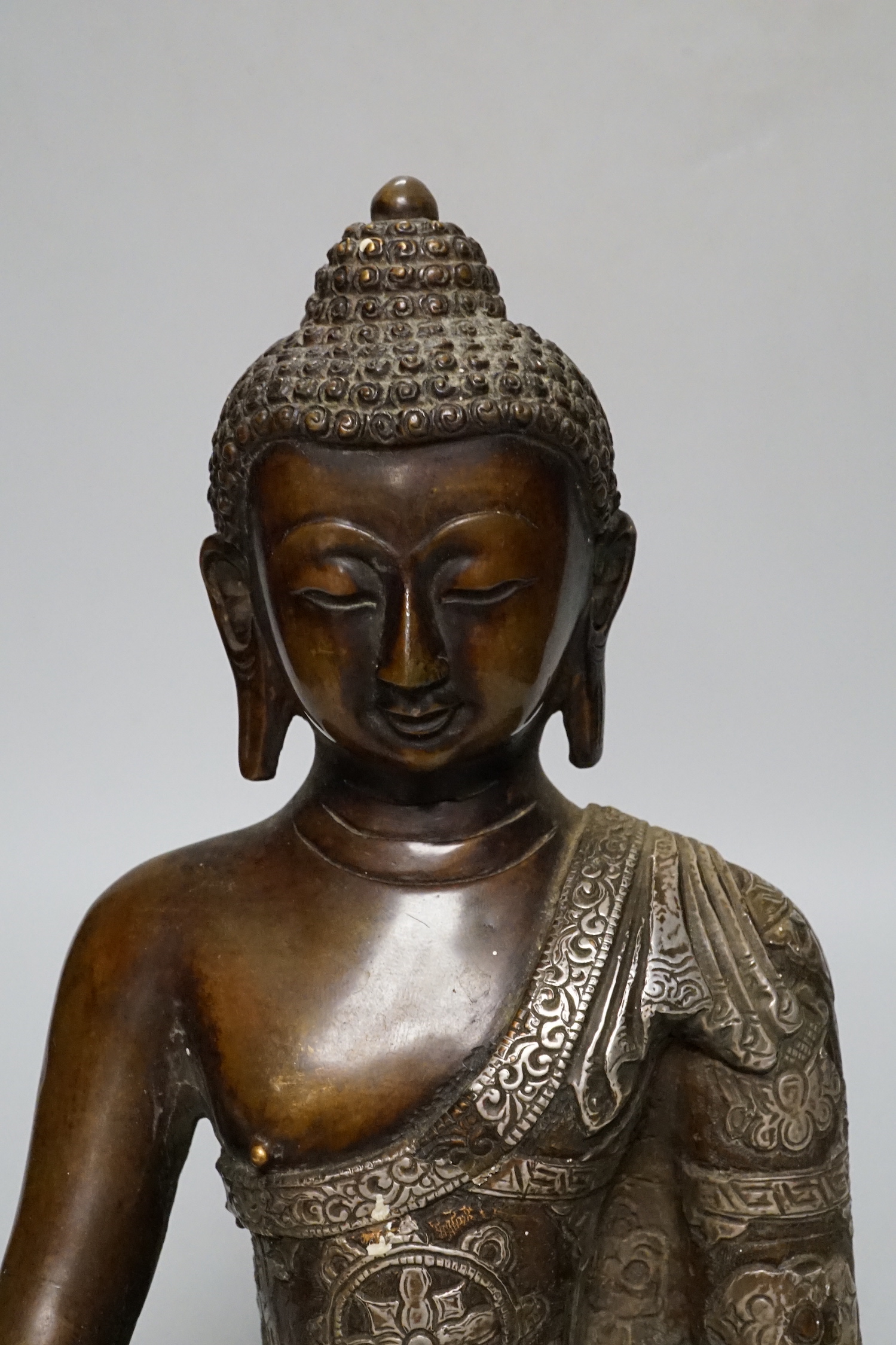 A silver overlaid bronze figure of Buddha Shakyamuni, 26cm